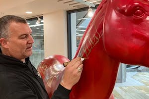 Famous graffiti artist Inkie decorates a large unicorn