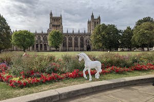A small unicorn foal stands outside a Bristol landmark